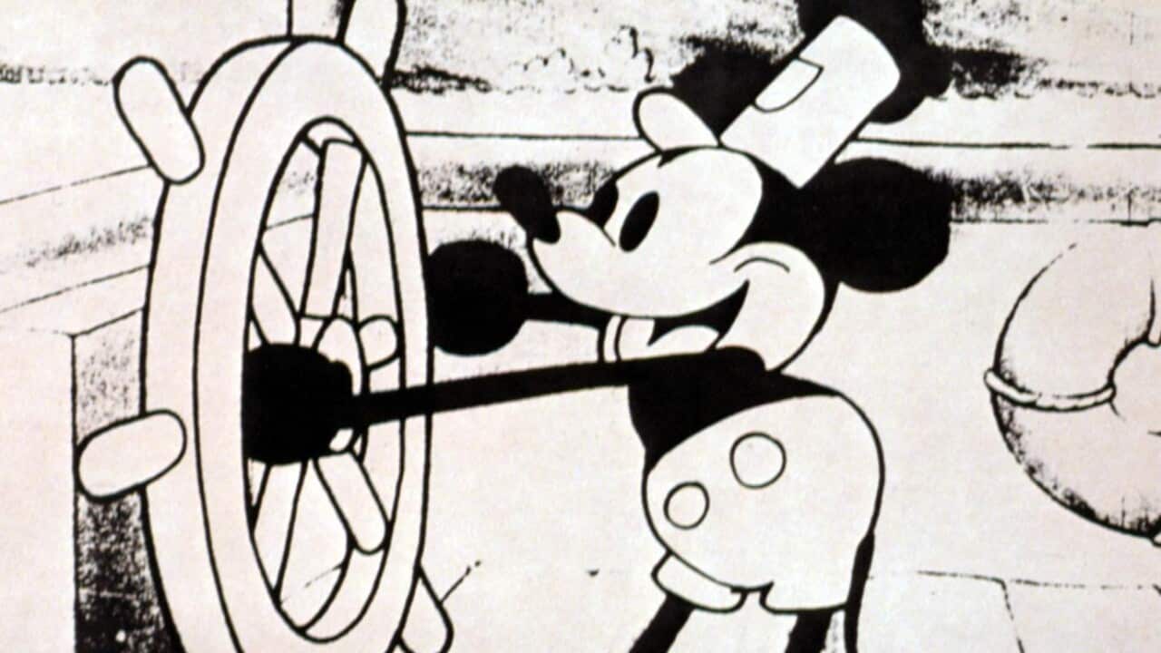 A black and white Mickey Mouse cartoon character is steering a boat.