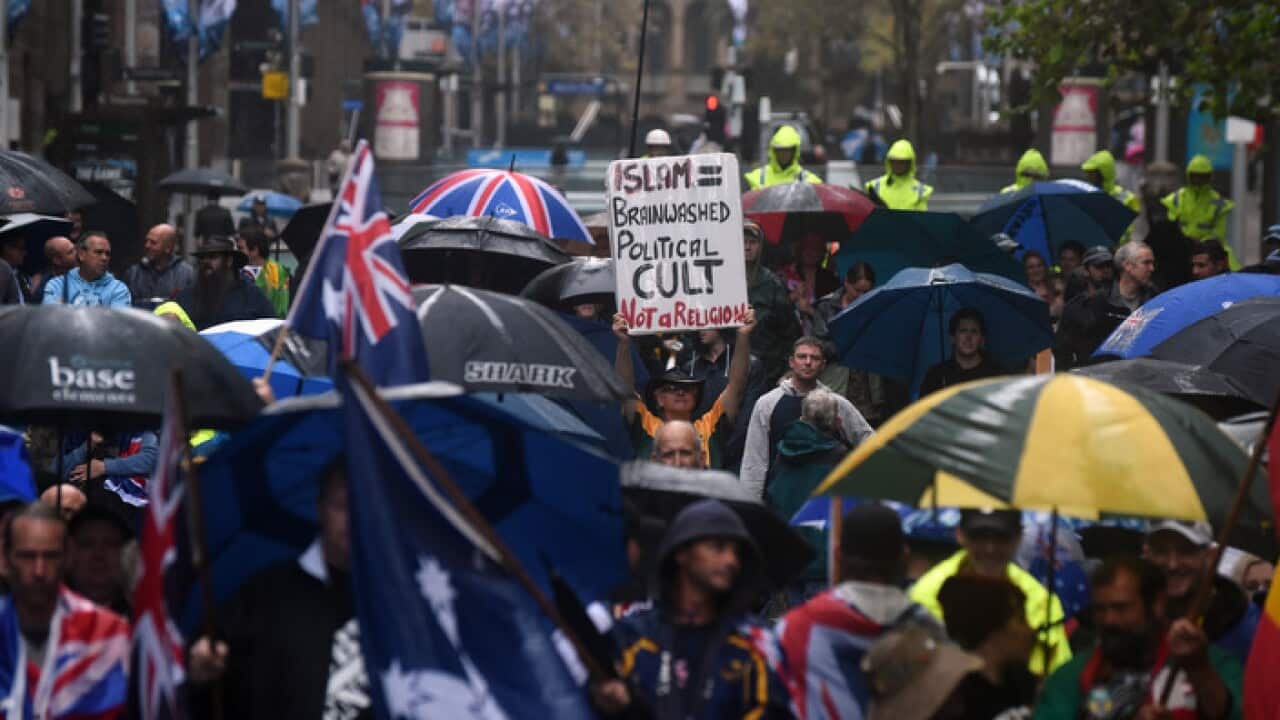 Protesters holding anti-Muslim placards are seen at a Reclaim Australia Rally at Martin Place in Sydney on Saturday, April 4, 2015. (AAP Image/Mick Tsikas)