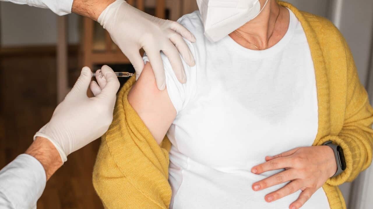 A pregnant woman takes the COVID vaccine.