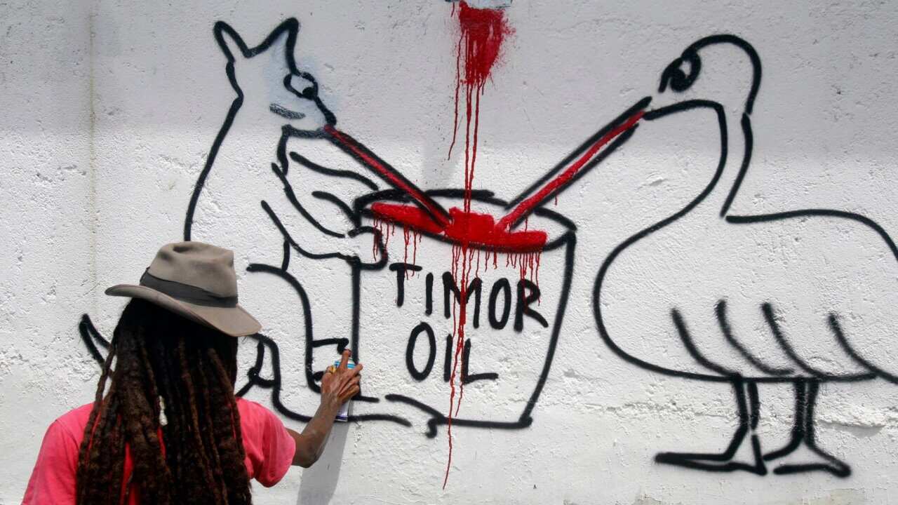 An East Timor activist paint Australian Embassy's wall during a protests at Australian Embassy in Dili, Timor Leste on 20 December 2013.