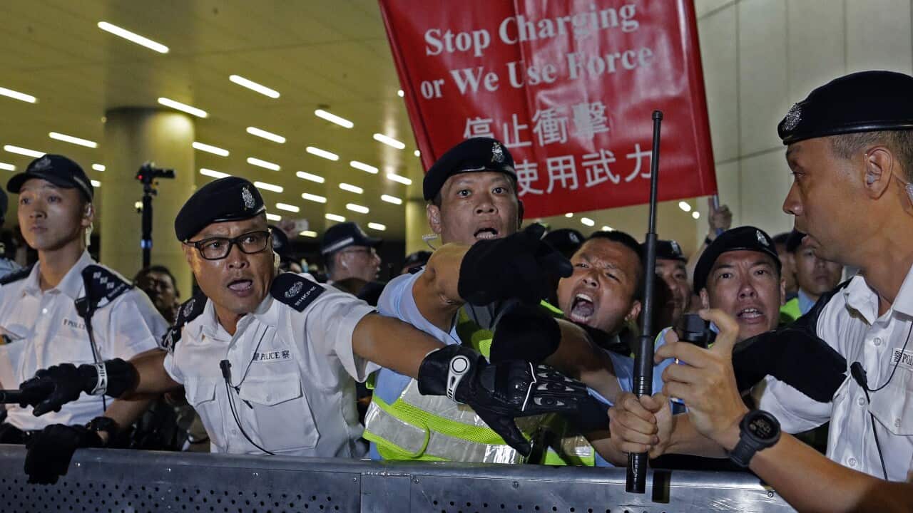 Police officers react as the clash against protesters in a rally against the proposed amendments to the extradition law
