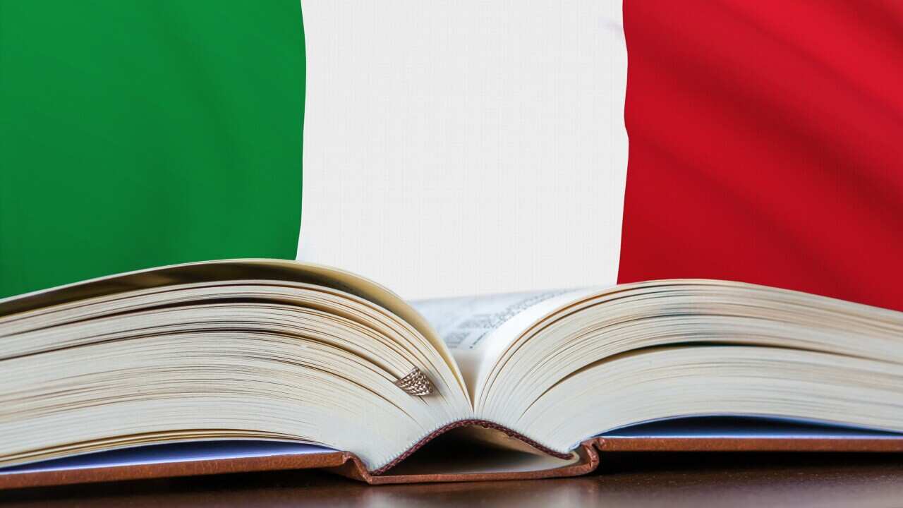 Opened book with Italianl flag on background.