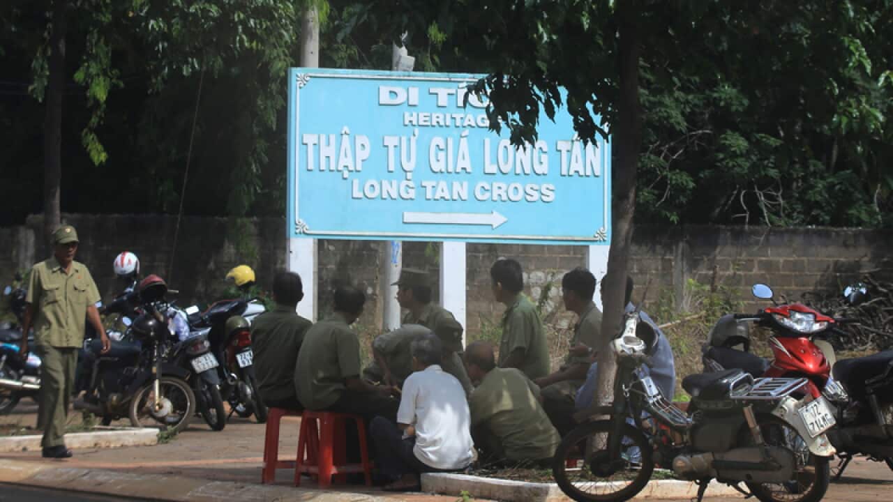 Security officers guard the entrance to the Long Tan Cross