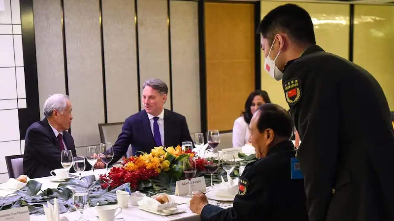 China's Defence Minister Wei Fenghe (R) laughs as Singapore's Defence Minister Ng Eng Hen (2nd L) shakes hands with Australia's Defence Minister Richard Marles.