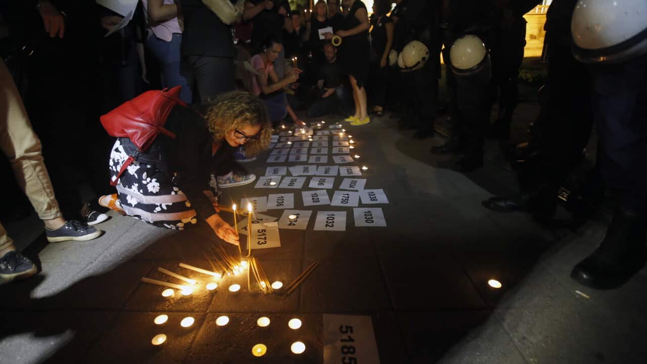 People light candles during a meeting to mark the 20th anniversary of the Srebrenica tragedy.