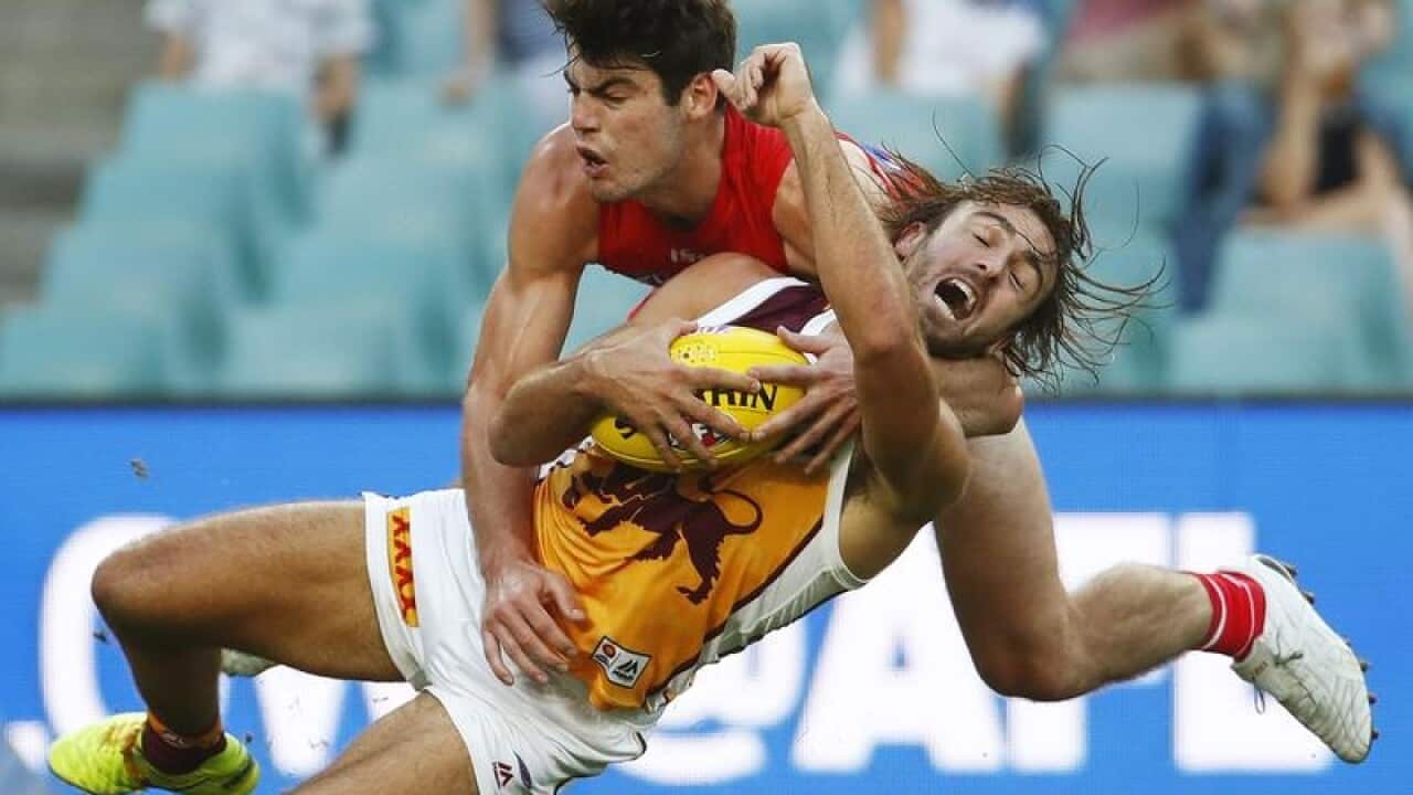 The Swans George Hewett tackles the Lions Rhys Mathieson.