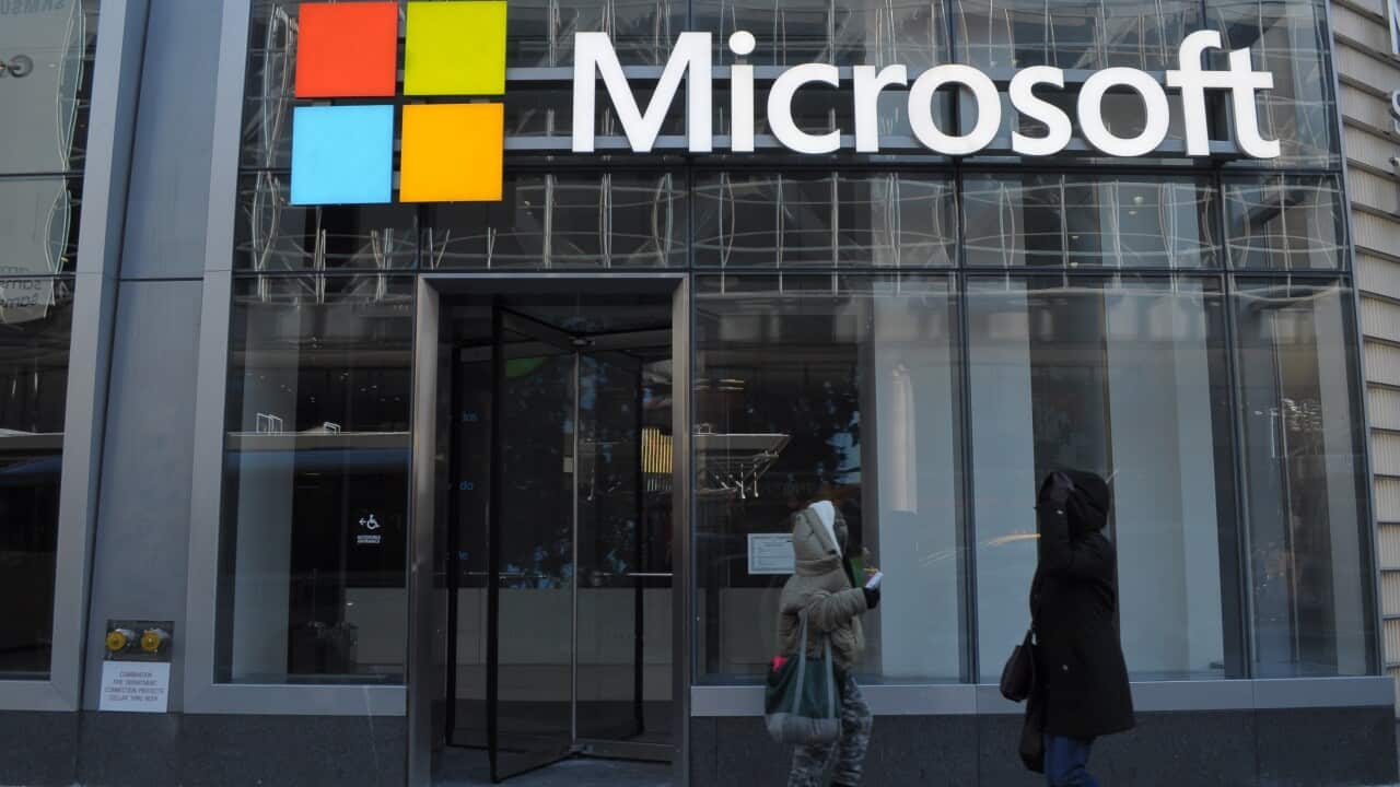 The exterior of a Microsoft office with the company's logo on the window.