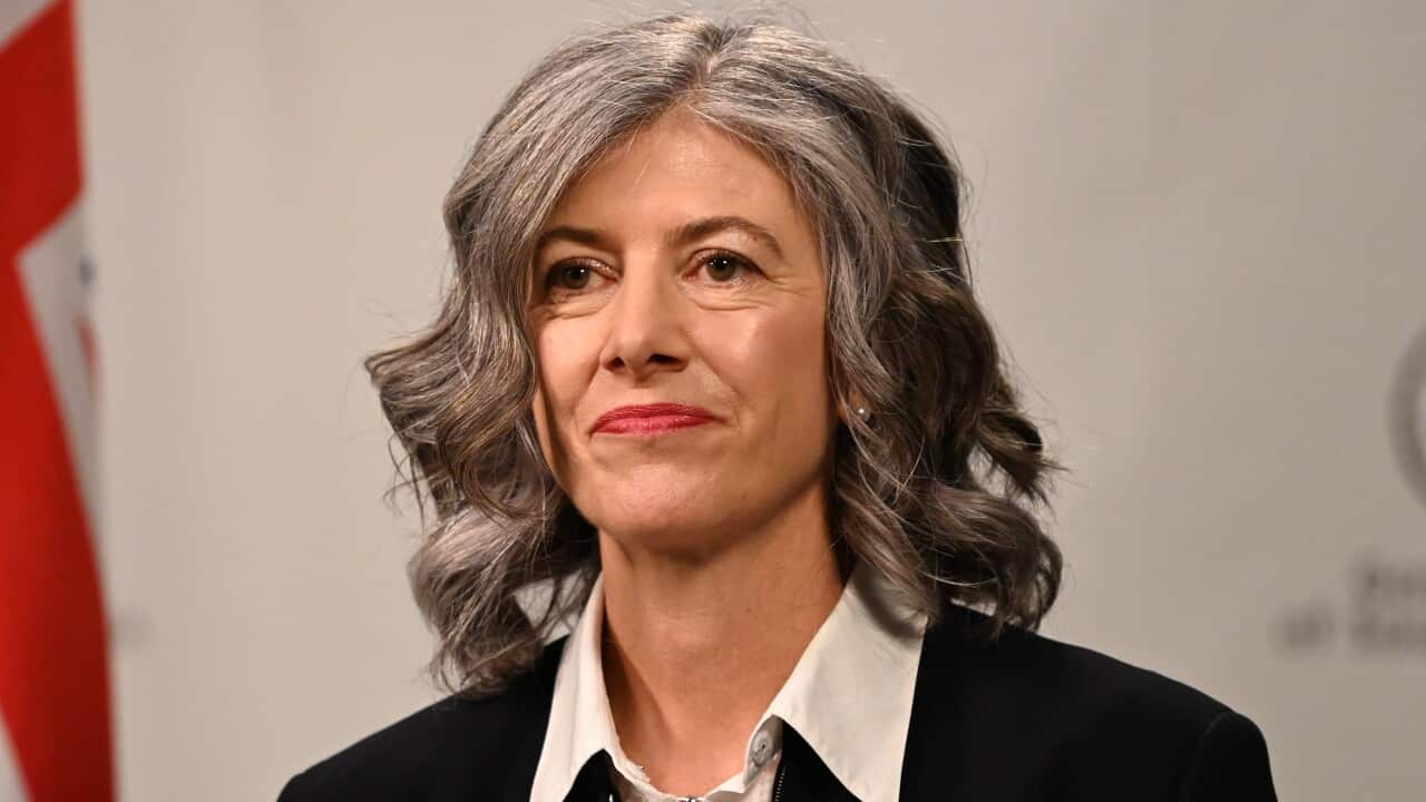 A woman standing in front of an Australian flag