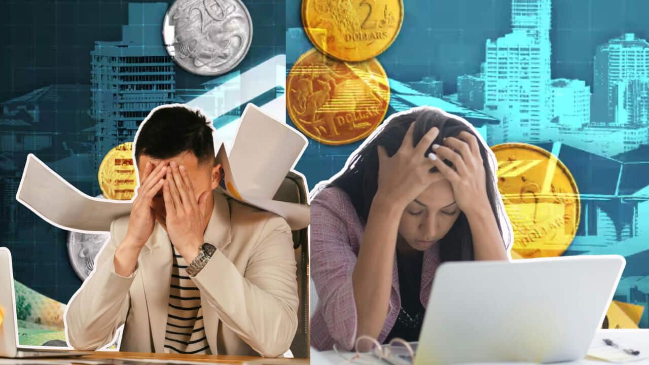 Two stressed office workers sit at computers surrounded by coins and financial graphics, symbolizing money problems or economic stress.