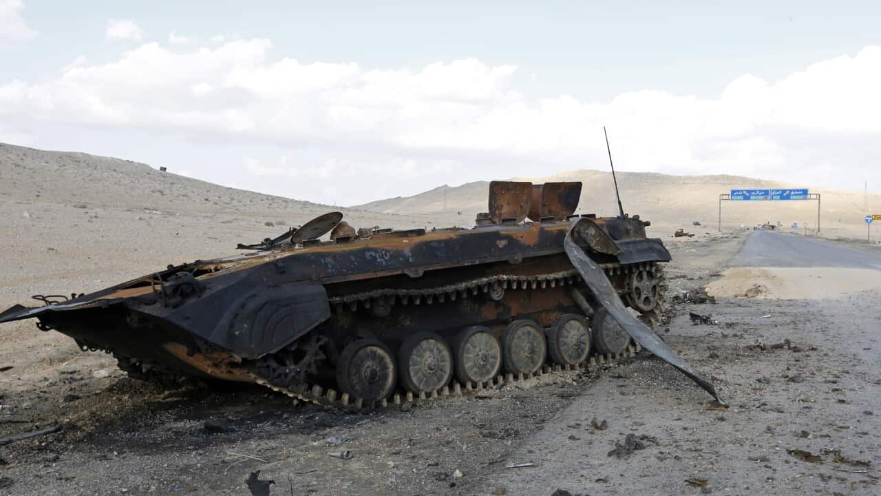A burnt-out tank stands at the entrance to the historical city of Palmyra, Syria.