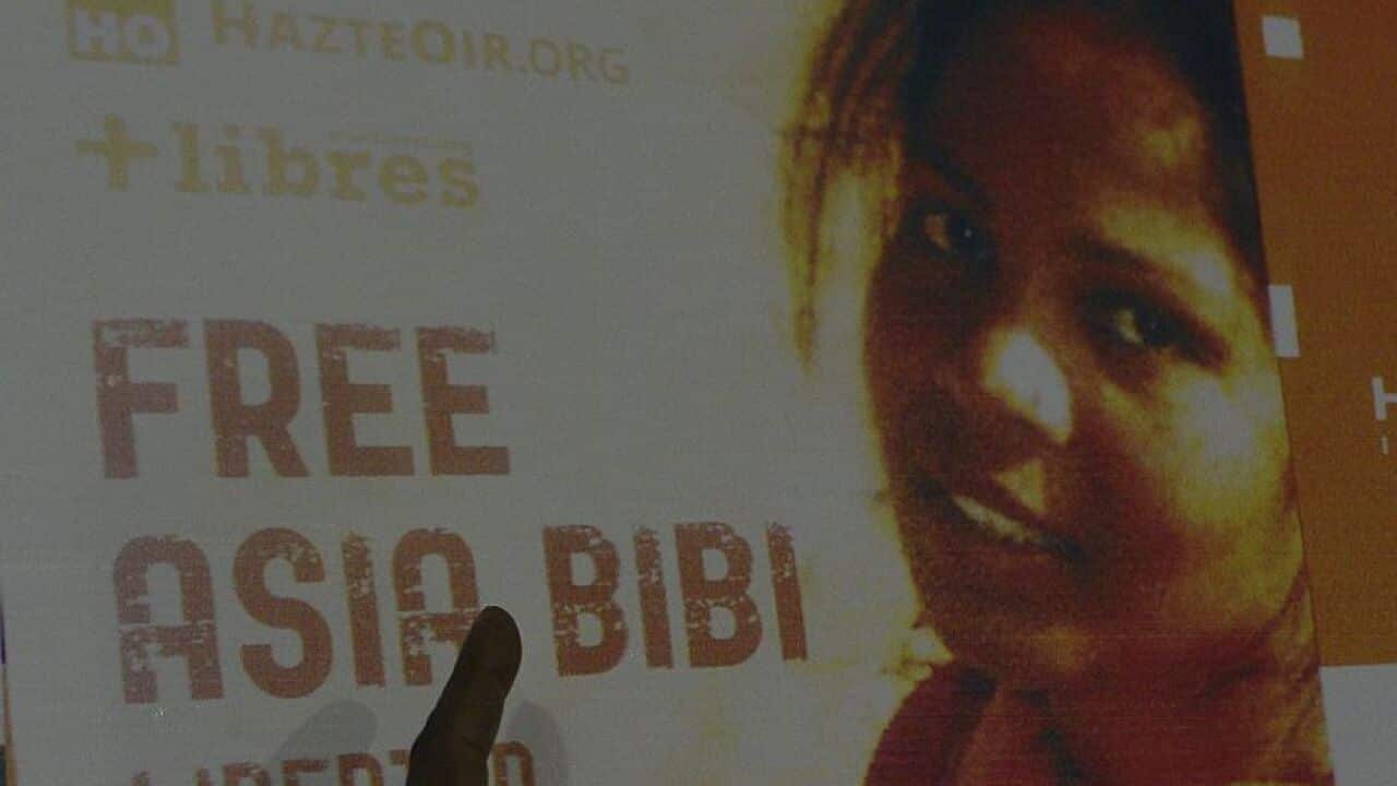 Ashiq Masih, husband of Asia Bibi, a Christian woman facing death sentence for blasphemy, points to a poster bearing an image of his wife.