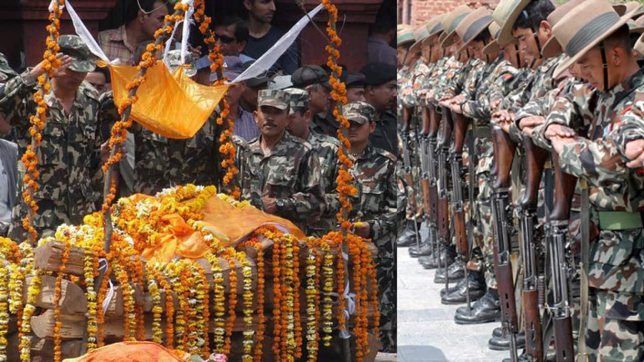 A line of Nepalese army pay last respect to the their colleague pilot Adesh Gorkhali during the funeral at Pashupati cremation center in Kathmandu