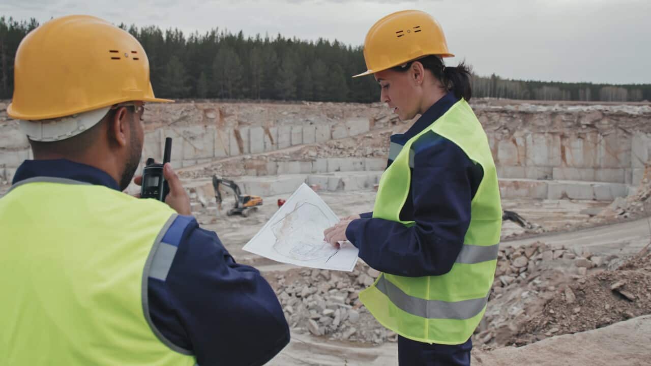 slowmo-tracking-shot-of-female-supervisor-in-safety-vest-and-hard-hat-looking-at-bluep-SBI-350713882 (2).jpg