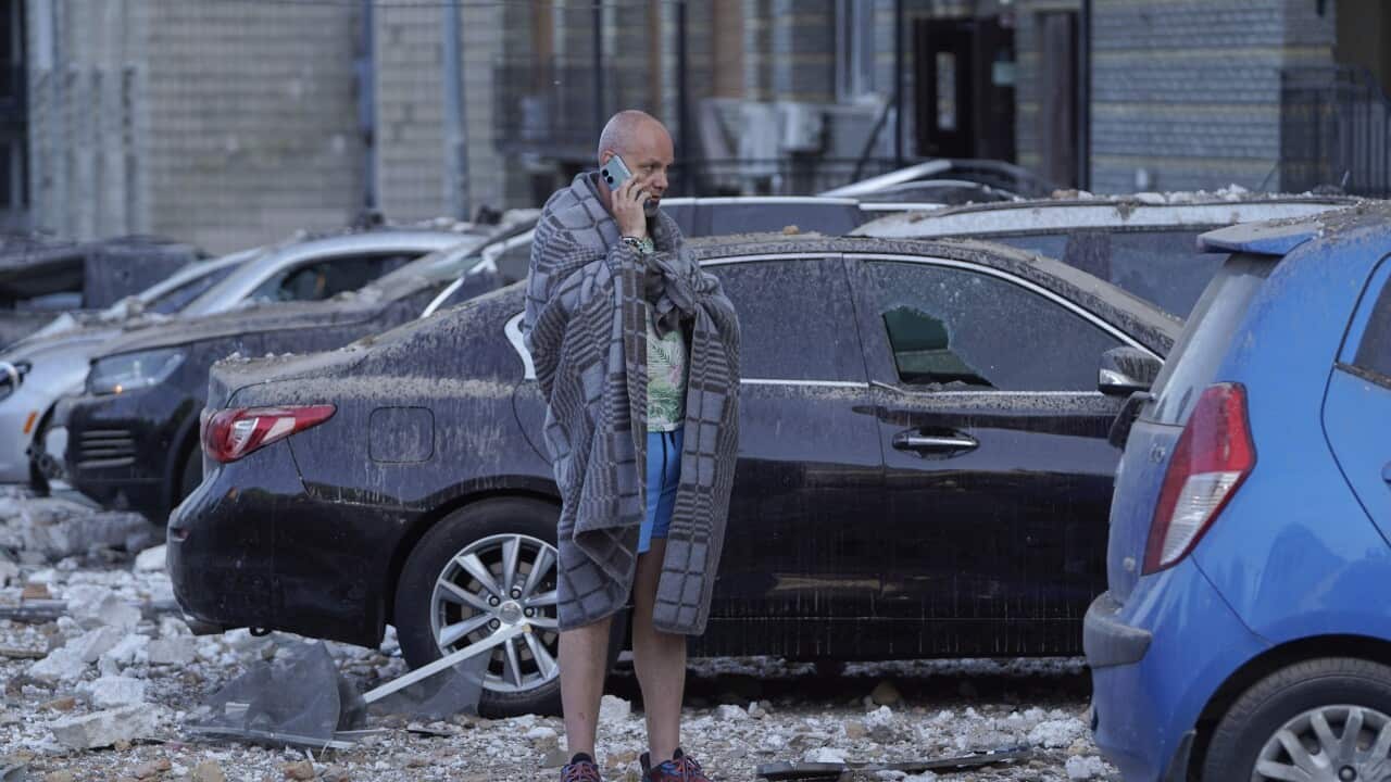A local resident stands amidst rubble outside an apartment building after it was damaged during a drone strike in Kyiv