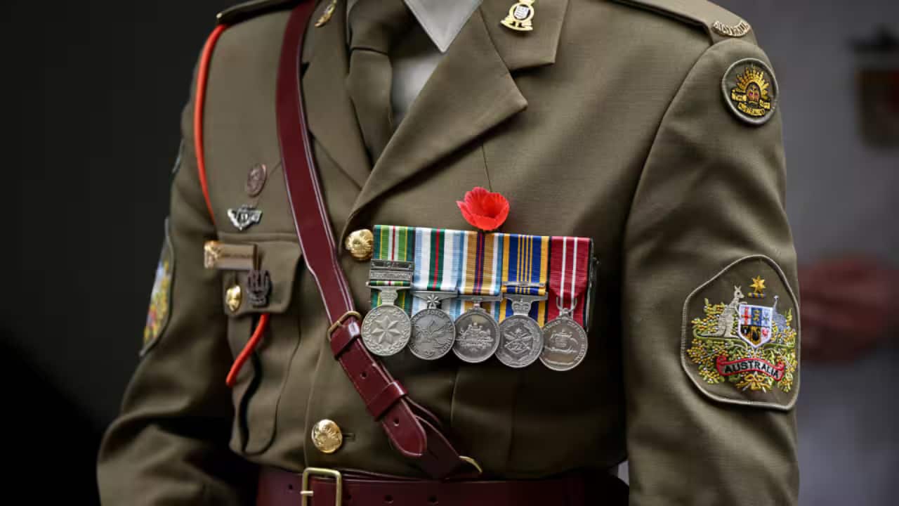 A flower in tribute with a medal of service on the uniform of a member of the Australian Defence Force.