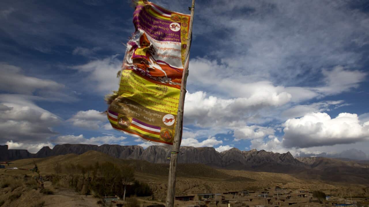A Tibetan religious flag is flown on a wall in China.