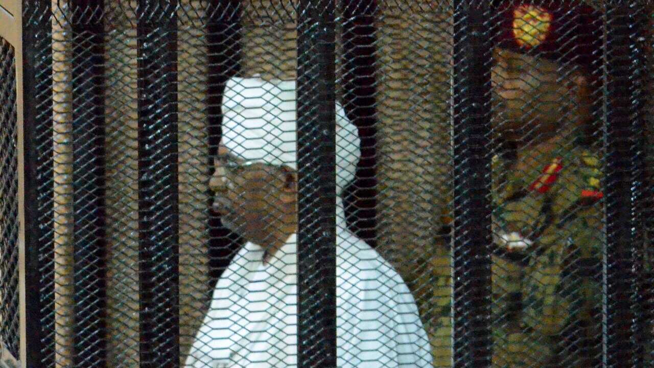 Sudan's ousted president Omar Hassan al-Bashir stands in a cage during his trial at a courtroom in Khartoum, Sudan.