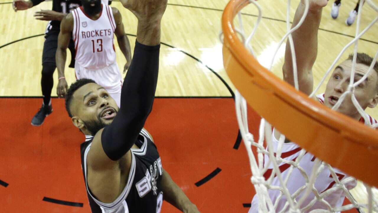 San Antonio Spurs' Patty Mills (L) goes up for a shot
