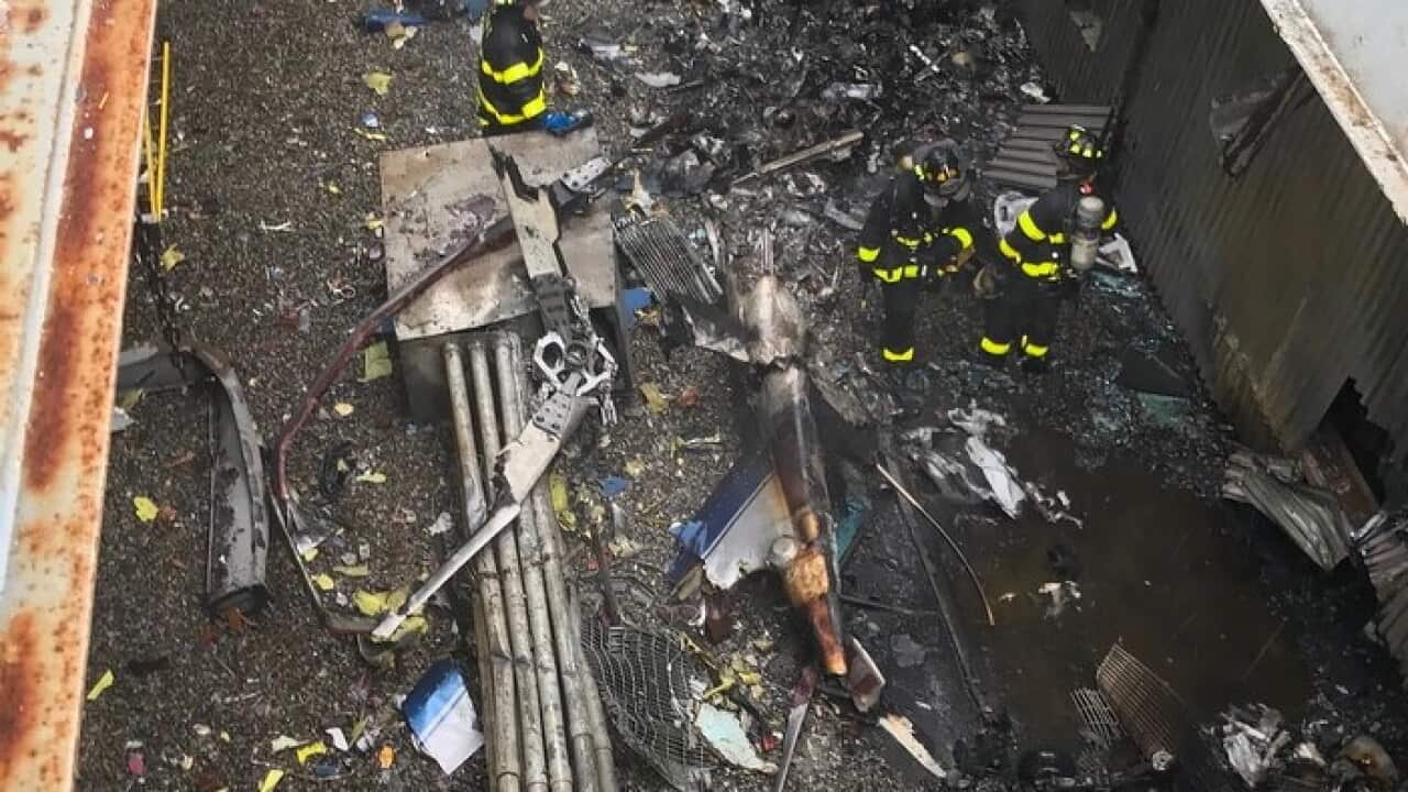 New York City firefighters working at the scene of the helicopter crash in midtown Manhattan