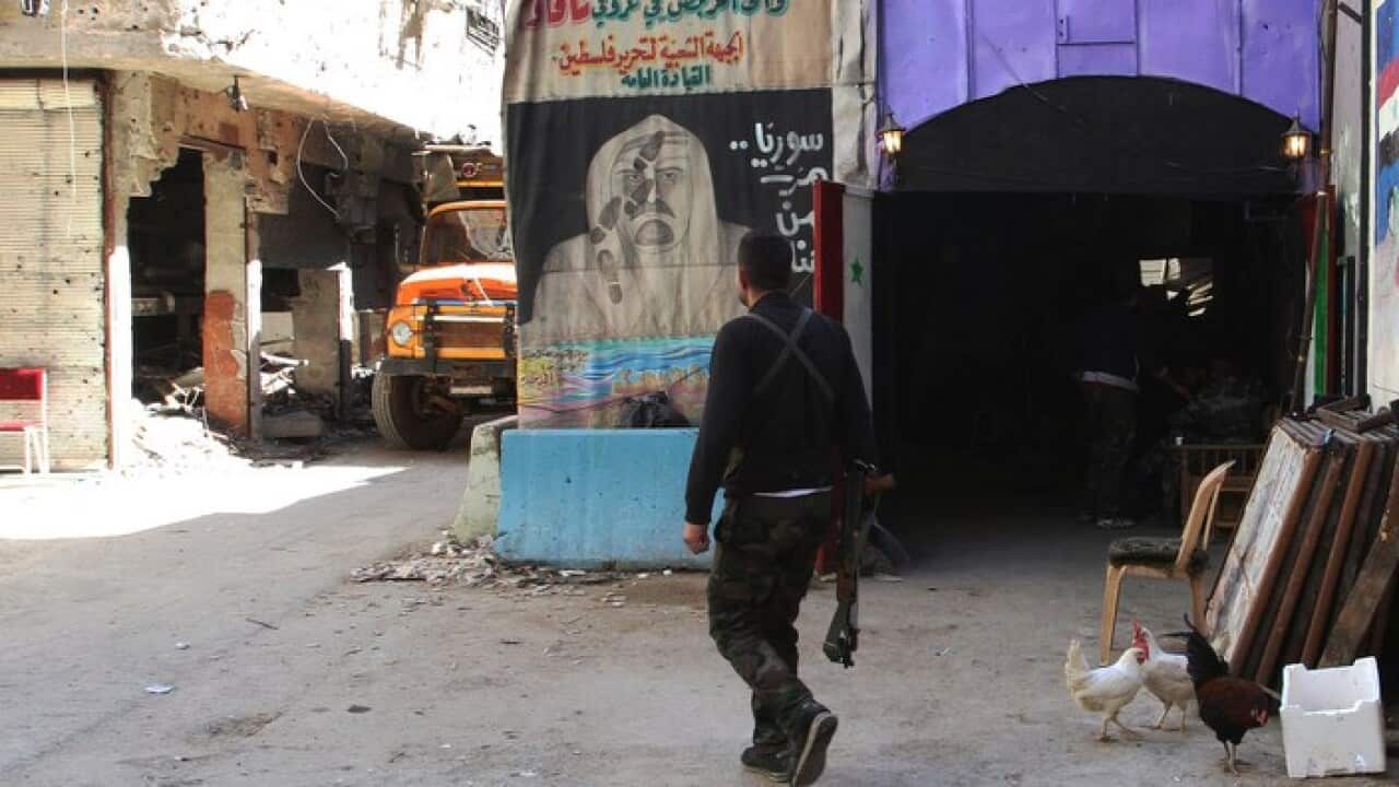 A man walks in a street inside the Yarmuk Palestinian refugee camp