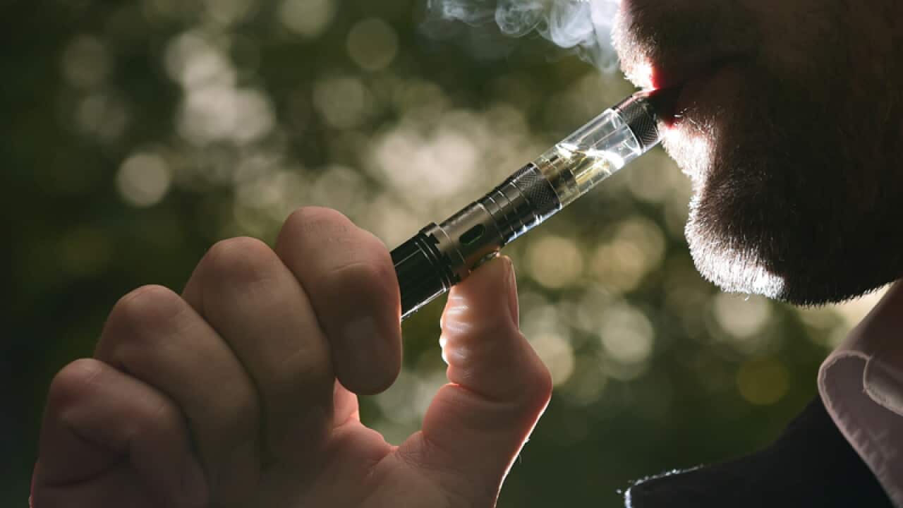 A person smokes from an e-cigarette