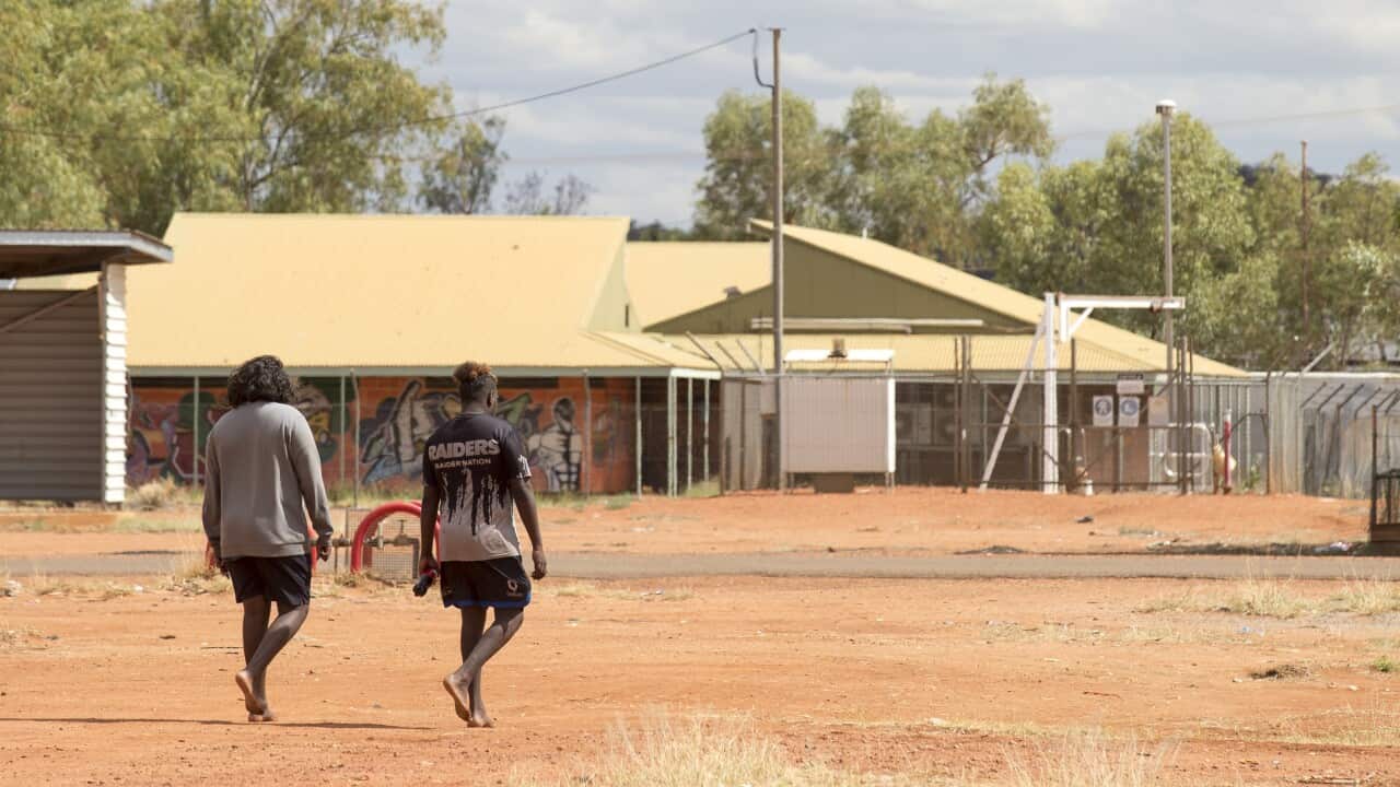 Two people walking in the outback community of Yuendumu