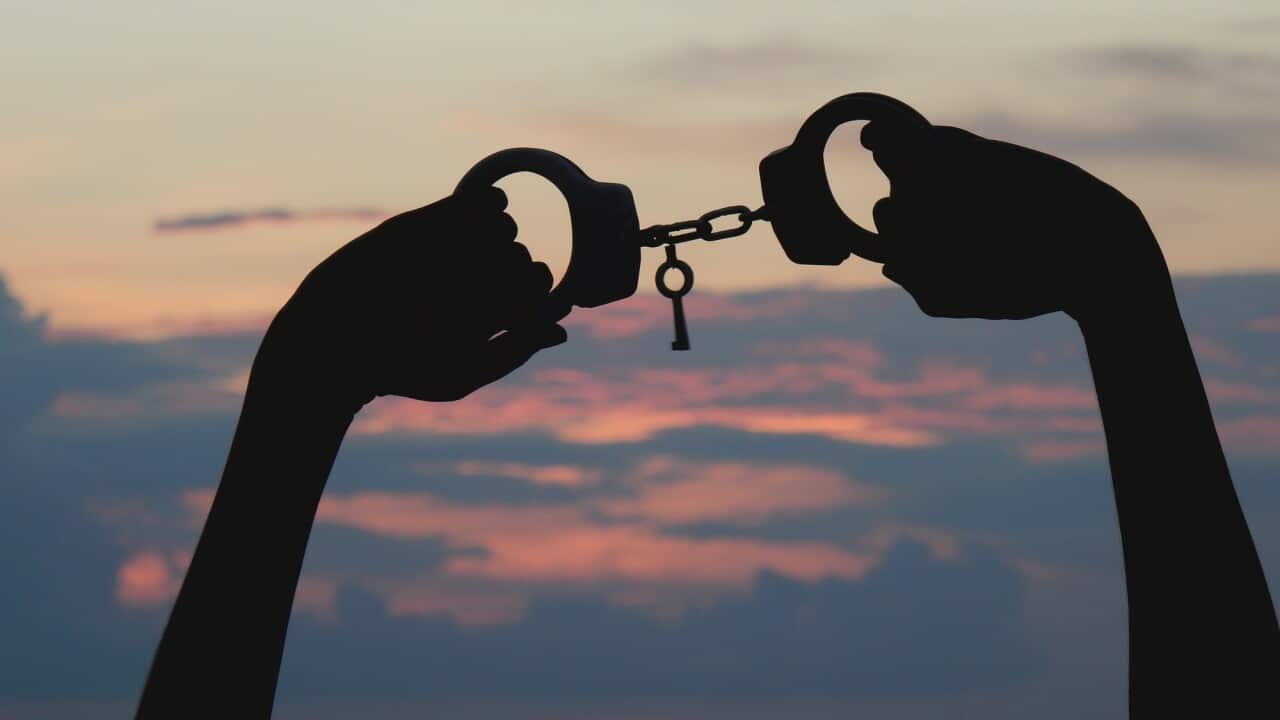 ands Holding Handcuffs Against Cloudy Sky During Sunset