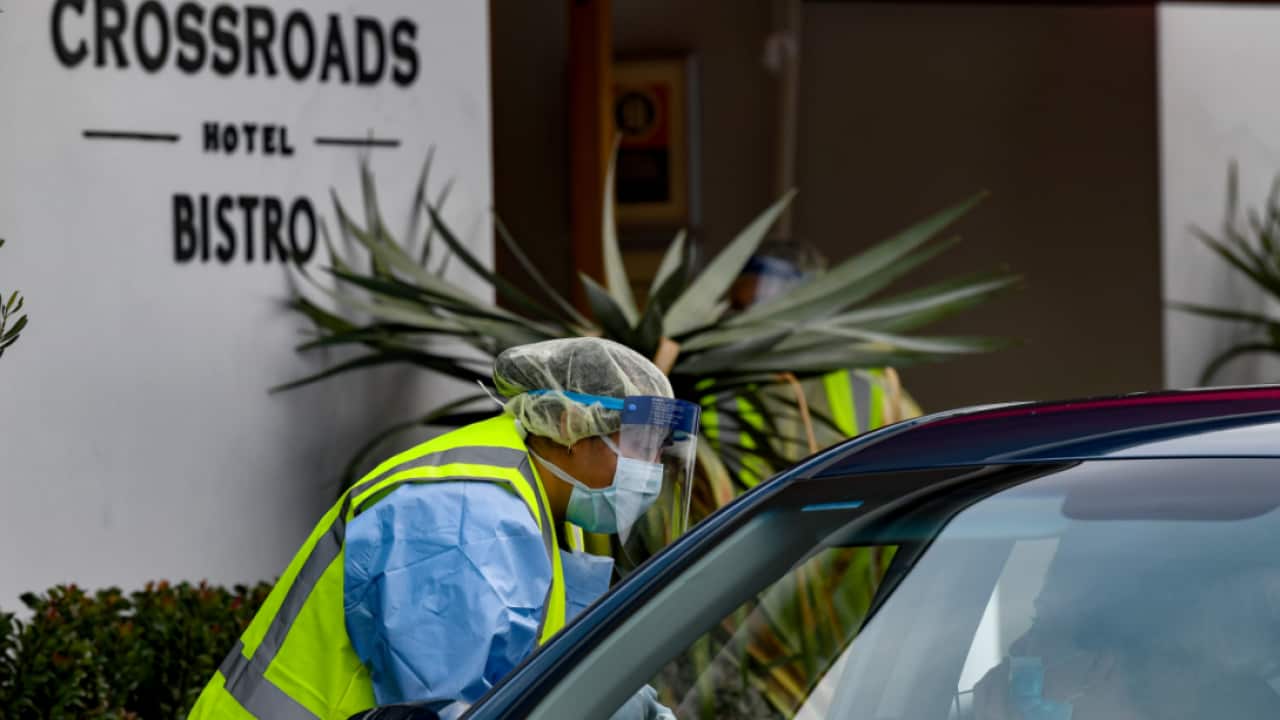 Workers administering COVID-19 tests to people in their cars at the Crossroads Hotel testing centre in Sydney, Saturday, July 11, 2020