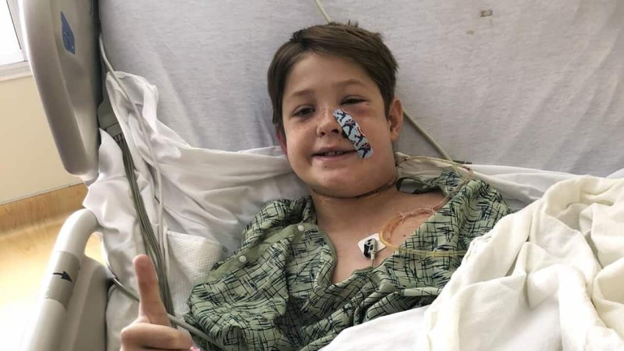 Xavier Cunningham gives the thumbs-up in hospital.
