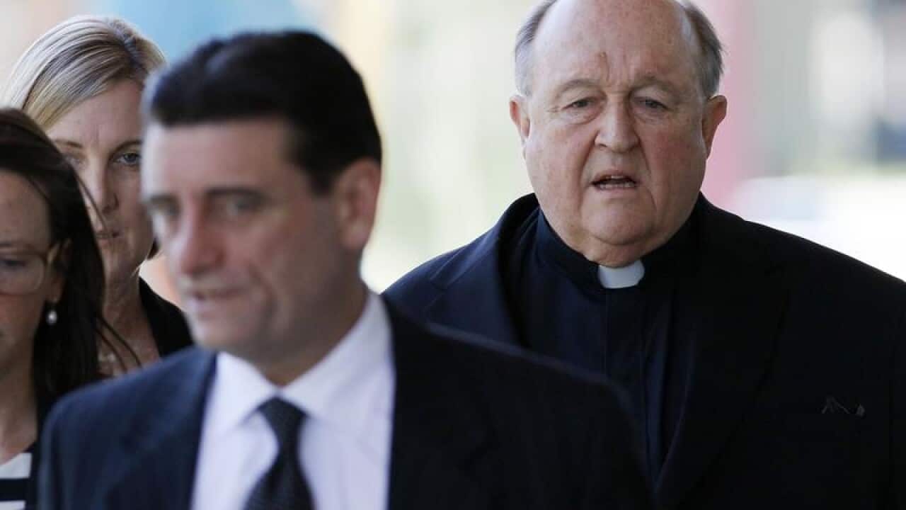 Archbishop Philip Wilson (right) arrives at Newcastle Local Court.