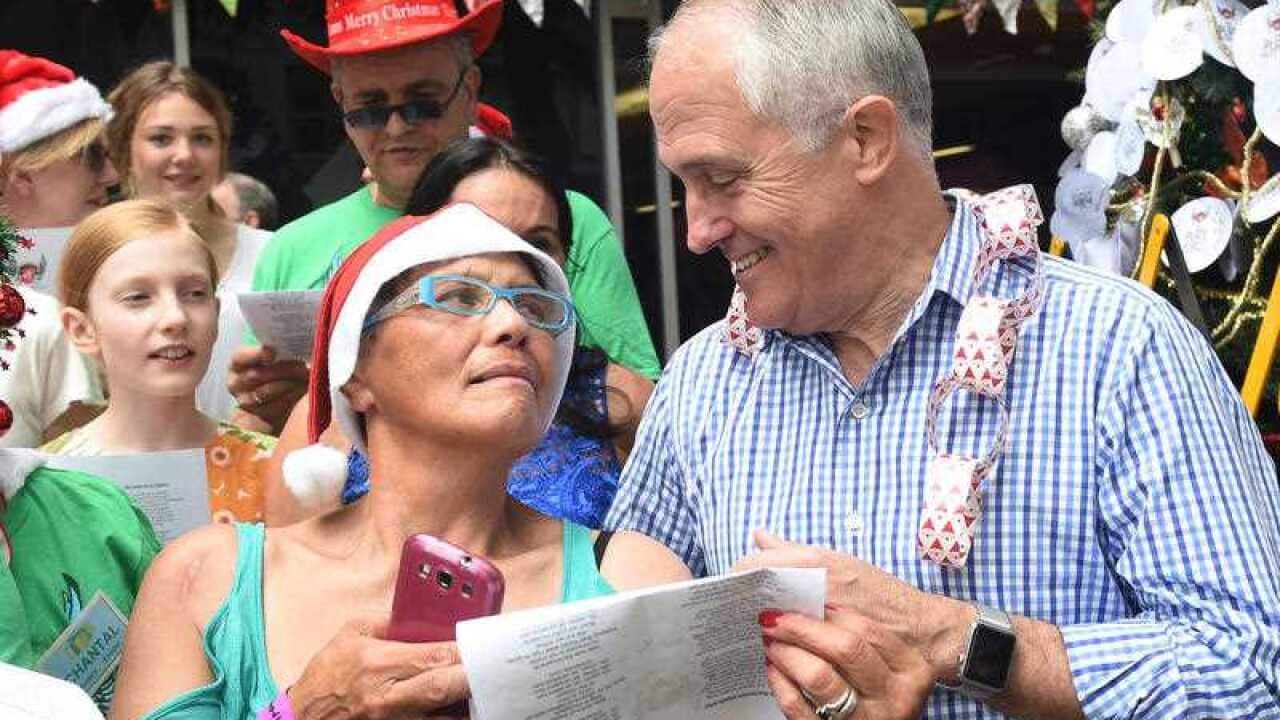 Australian Prime Minister Malcolm Turnbull (right) sings with a choir at the Wayside Chapel Christmas Day Street Party in Sydney.