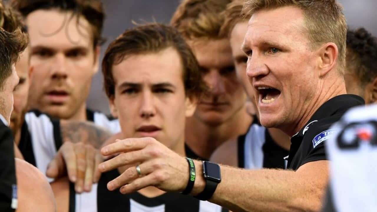 Collingwood coach Nathan Buckley chats with his players
