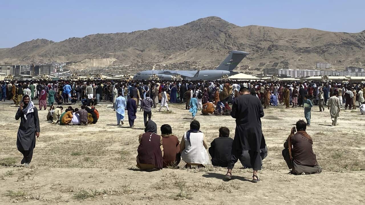 Hundreds gather near a US transport plane at the perimeter of Kabul's airport