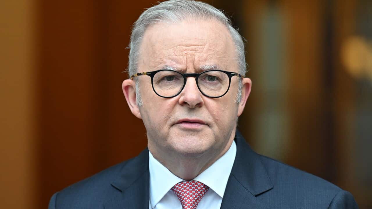 Anthony Albanese, wearing a dark blue blazer, white shirt and red tie.