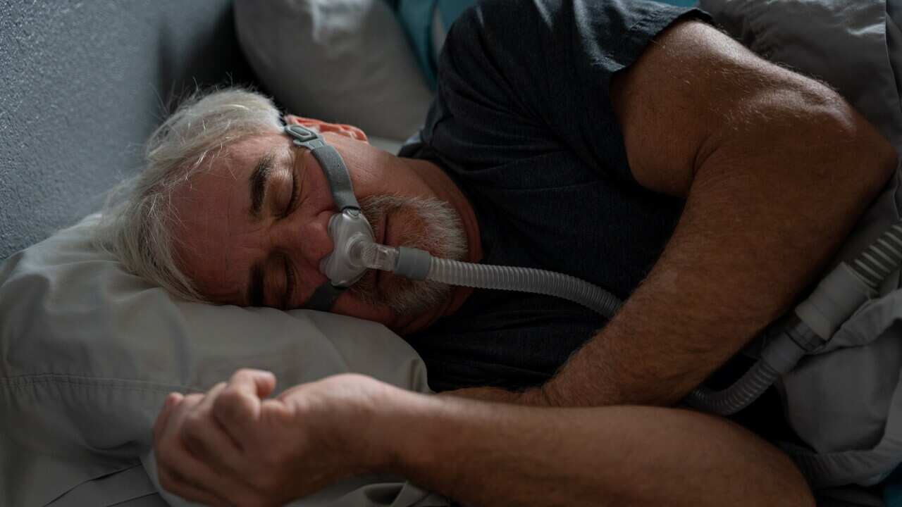 A sleeping man wearing a CPAP mask