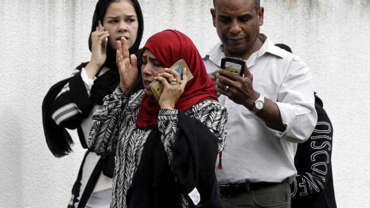 People wait outside a mosque in central Christchurch.