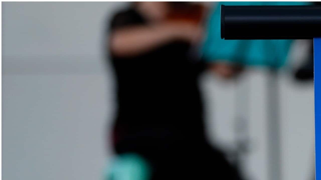 A musician plays a violin behind a photograph of cinematographer Halyna Hutchins during a vigil in her honor in Albuquerque,