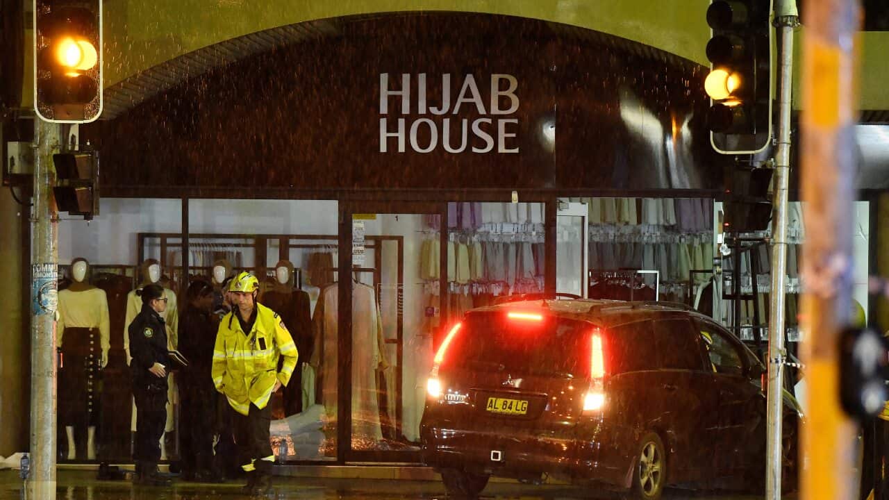 Emergency services remove the SUV from Hijab House, after it crashed through the front window, injuring at least 10.