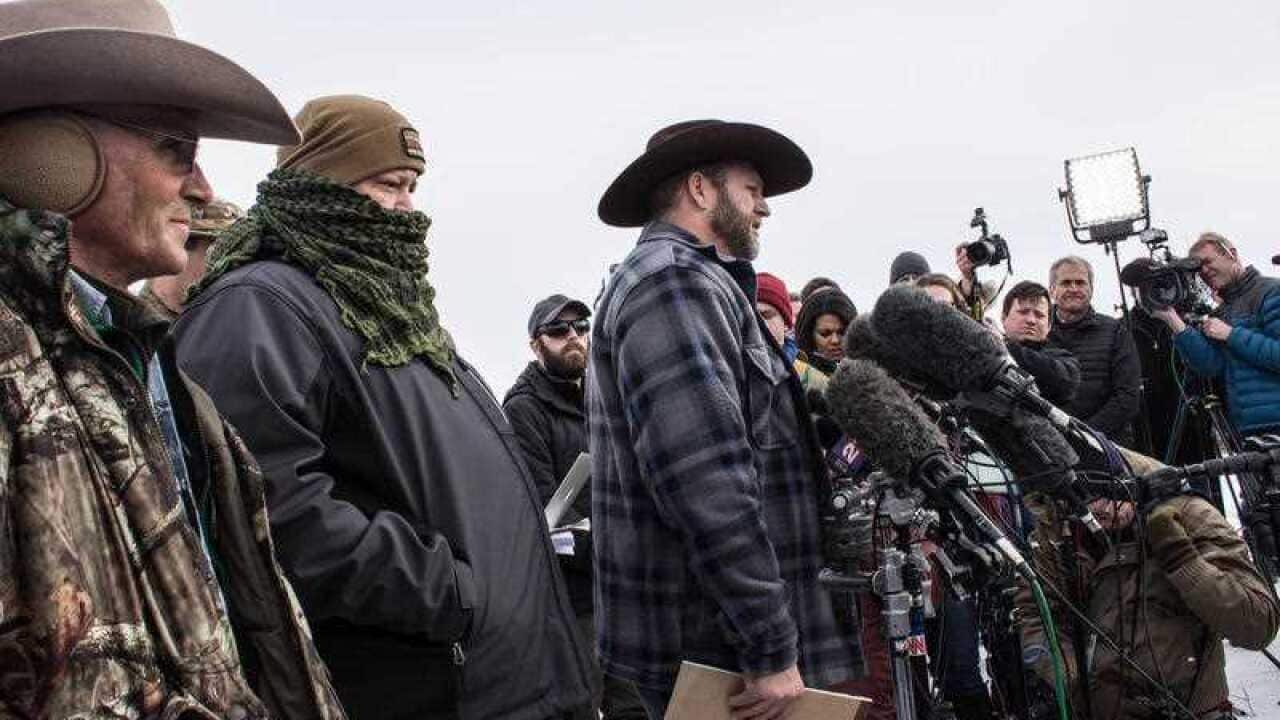 Ammon Bundy (center) speaks to the press alongside now-deceased LaVoy Finicum