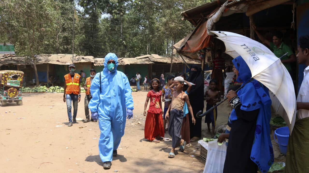 A health worker from an aid organisation walks wearing a hazmat suit at the Kutupalong Rohingya refugee camp in Cox's Bazar, Bangladesh.