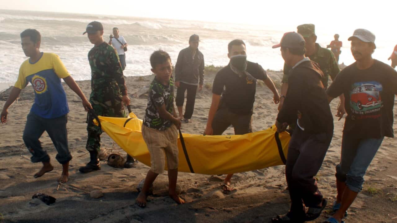 Rescuers carry the body of a victim of an asylum-seeker boat sinking