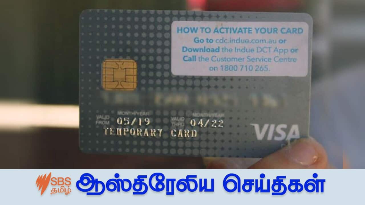 A person holds a cashless welfare card.