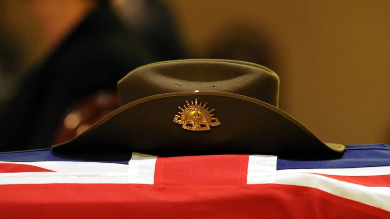 An Australian army slouch hat rests on a coffin