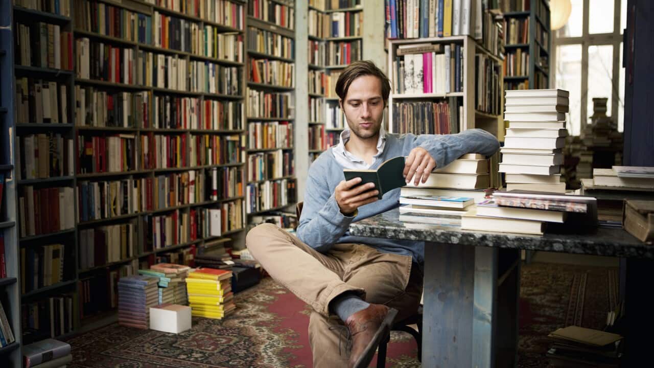 Man reading books in bookstore