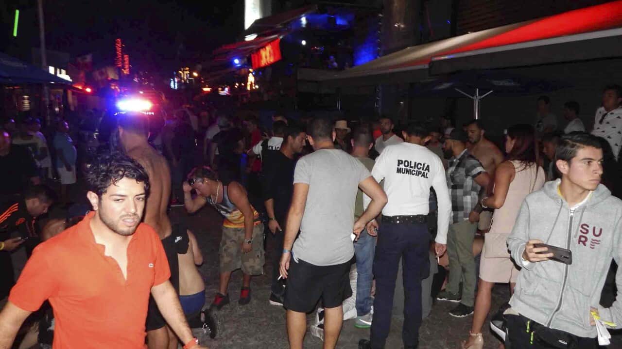 In this photo people react after a shooting at the outdoor venue Blue Parrot nightclub in the Caribbean coast resort of Playa del Carmen, Mexico.
