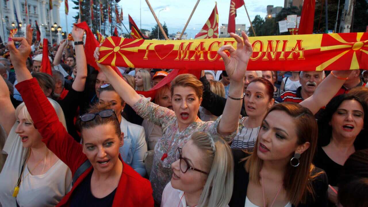 People chant during a protest over the proposed change, in front of the Government building in Skopje, Macedonia. 