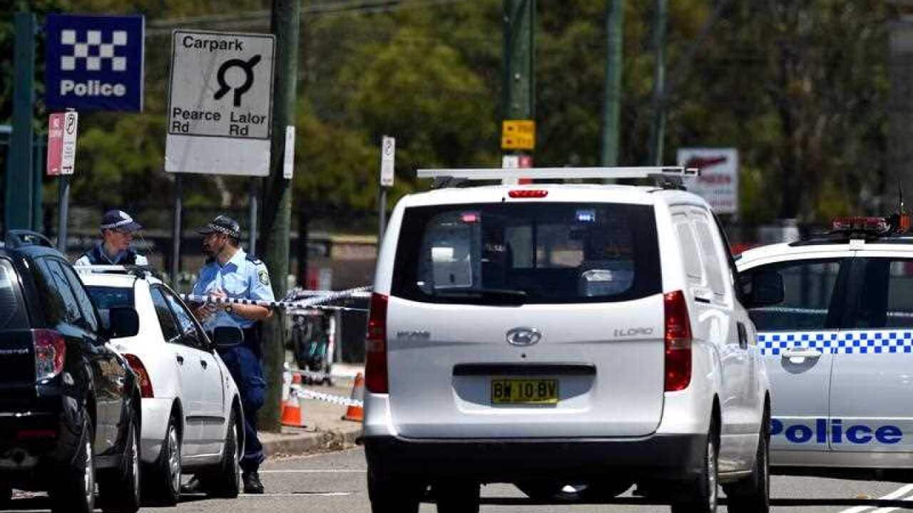 Police officers stand outside of the Quakers Hill Police Station in Sydney.