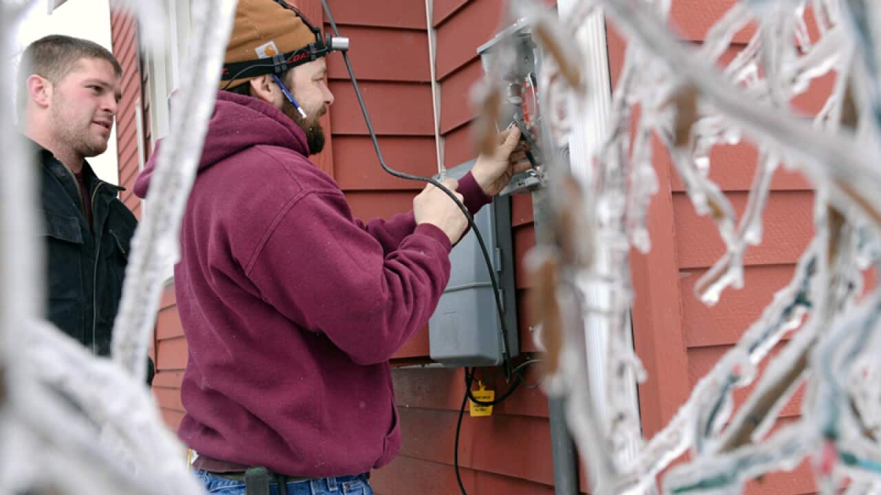 Workers replace an electrical box in Michigan