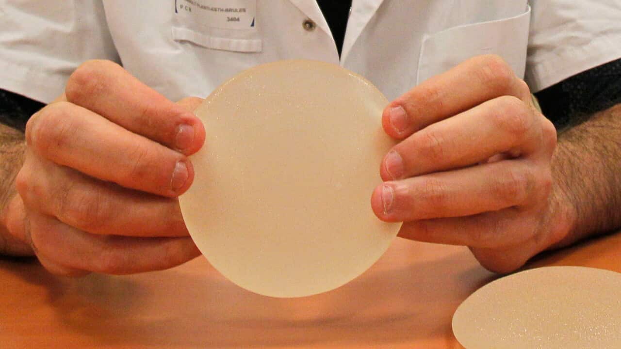 Dr. Maurice Mimoun, a plastic surgeon at the St Louis hospital, holds a silicone gel breast implant made by French company Poly Implant Prothese, or PIP, that he removed from a patient because of concerns that they are unsafe, Paris, Wednesday, Dec. 21, 2