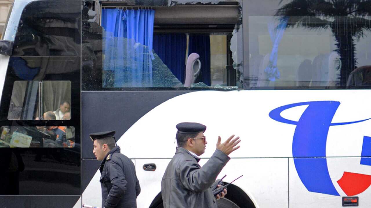 Egyptian police officers near a bus following an attack